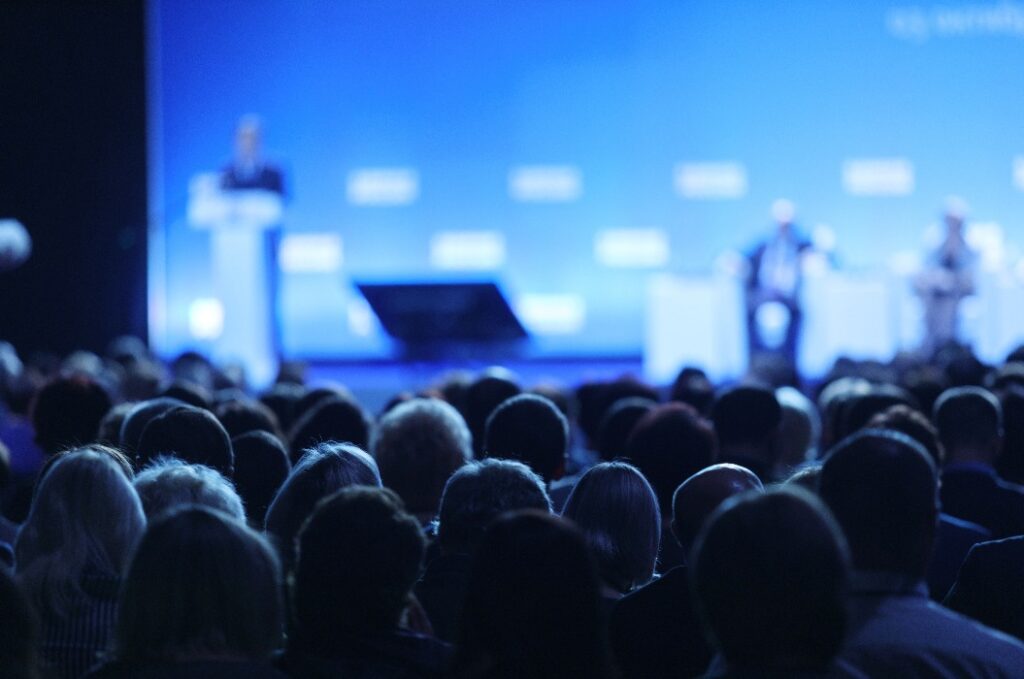 A speaker gives a presentation at a business meeting. Audience in the conference room. 