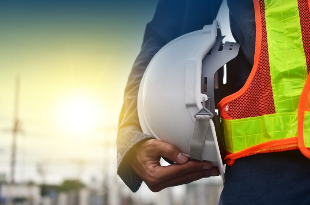 Techniker hält weißen Hut Sicherheit harten Hut Sonnenlicht Hintergrund