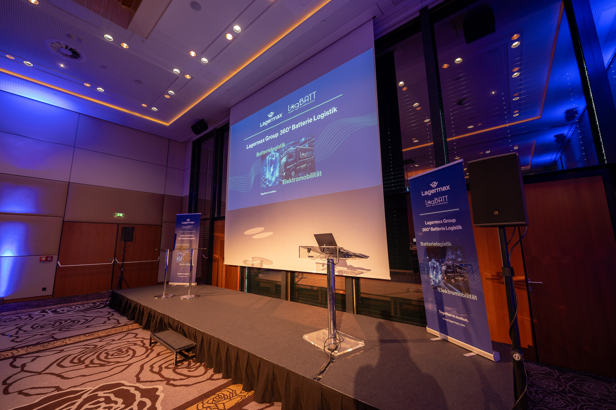 Eine leere Bühne bei einer Konferenz mit blauer Beleuchtung und zwei Rednerpulten.