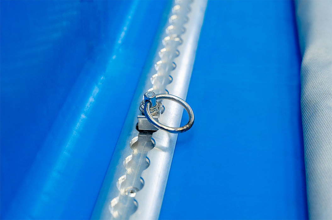 A silver ring lies on a blue, textured surface.